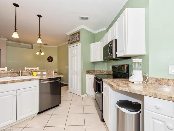 a kitchen with kitchen island granite countertop a sink a stove and dishwasher