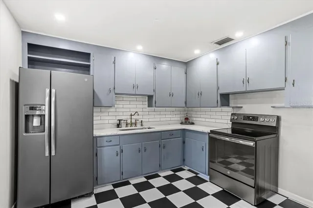 a kitchen with stainless steel appliances granite countertop a stove a refrigerator and a sink