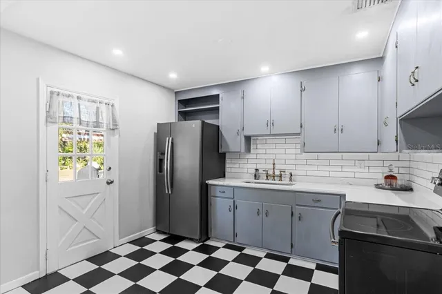 a kitchen with a sink a refrigerator and cabinets