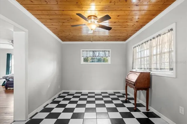 a room with a black white checkered floor with a gaming machine and dining table