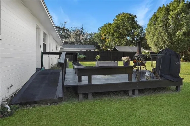 a view of backyard with deck and a garden