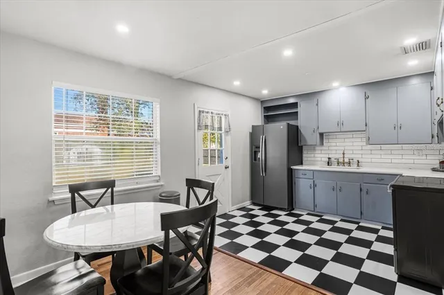 a kitchen with a table chairs refrigerator and microwave