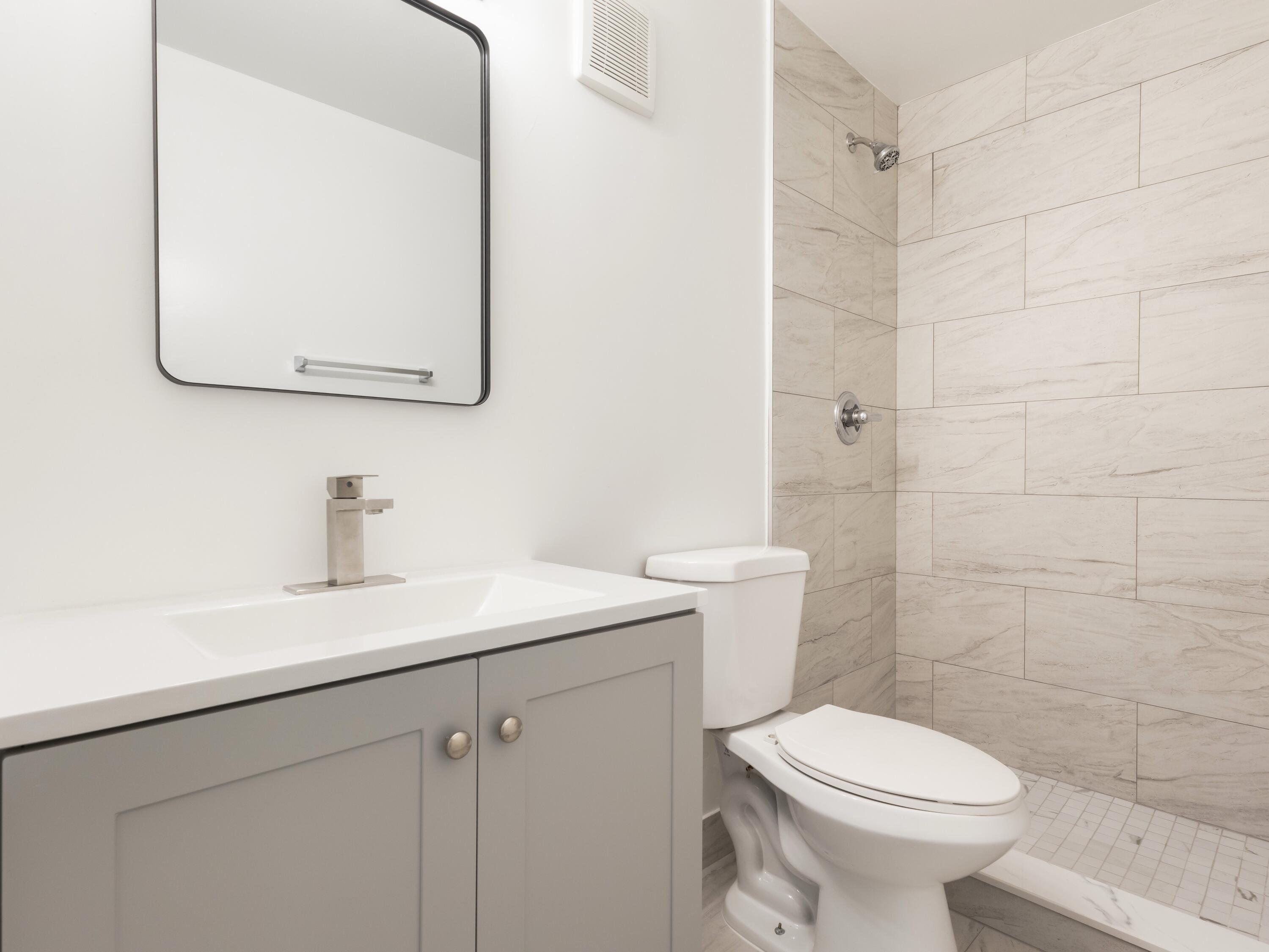 450 Southwest 2nd Avenue, Unit 2050 Boca Raton, FL 33432 - Photo 10 of 11 a bathroom with a toilet sink vanity and mirror