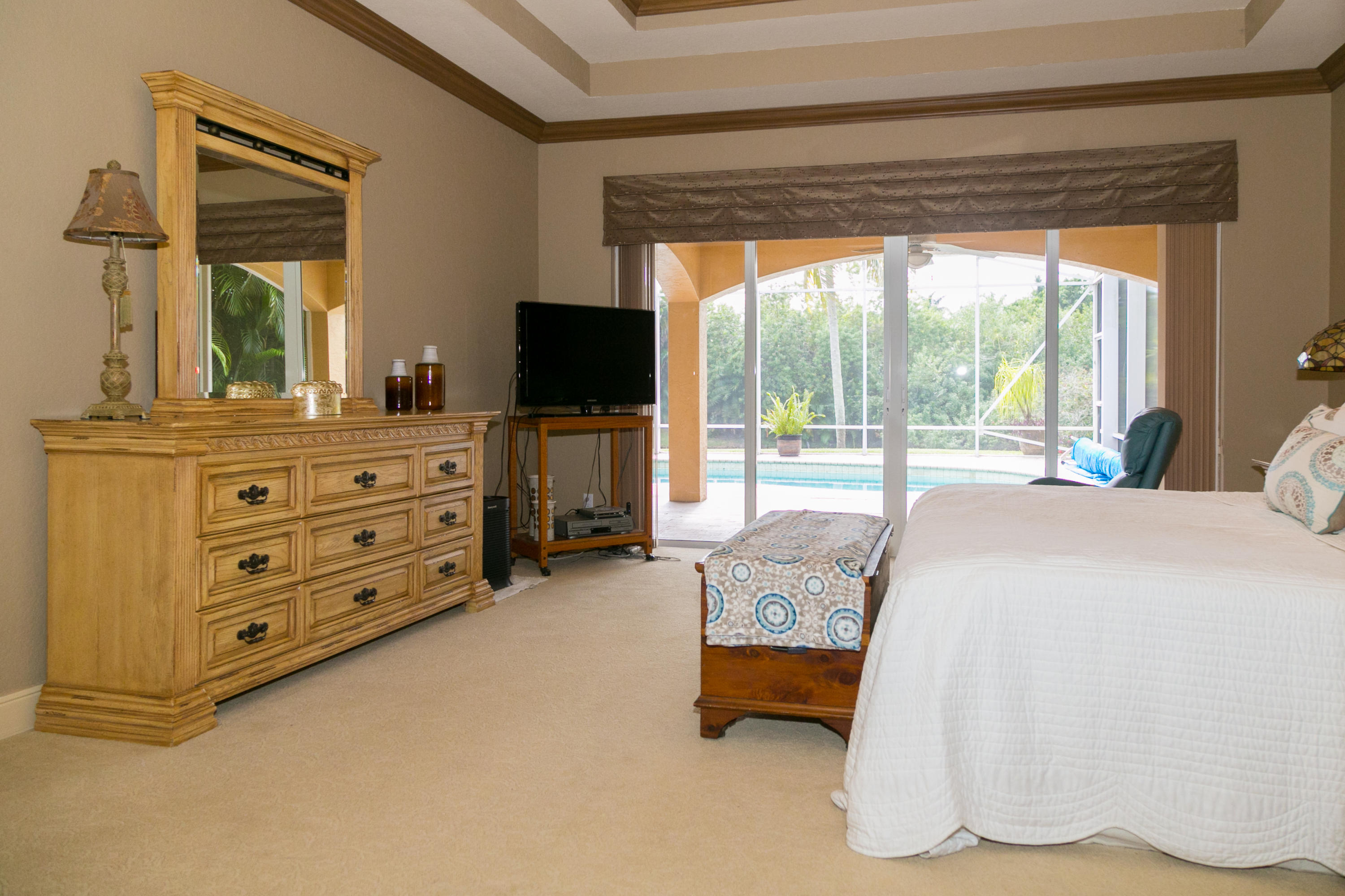 8666 Sawpine Road Delray Beach, FL 33446 - Photo 19 of 49 a bedroom with furniture and a flat screen tv