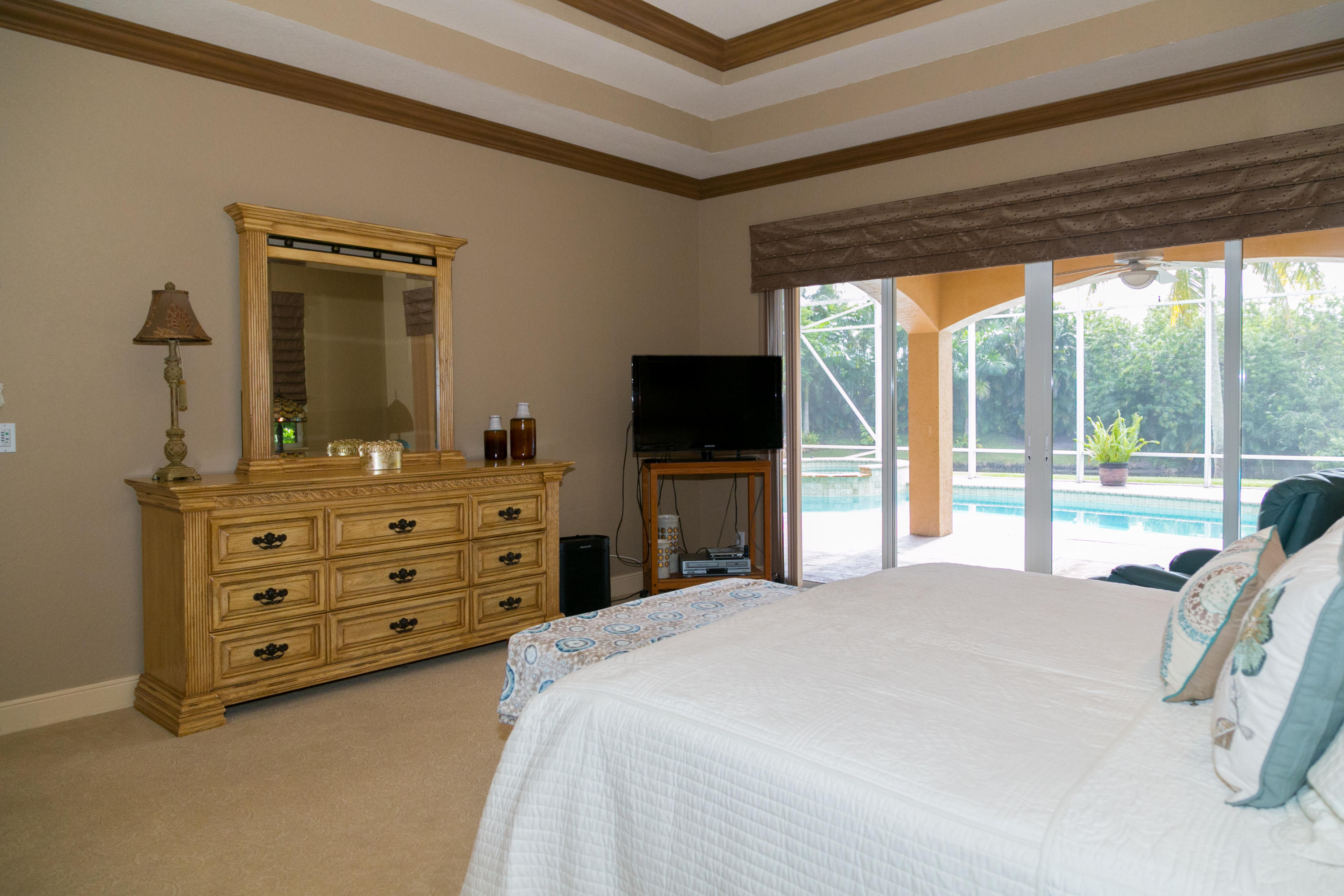 8666 Sawpine Road Delray Beach, FL 33446 - Photo 20 of 49 a bedroom with a bed and a flat tv screen on dresser