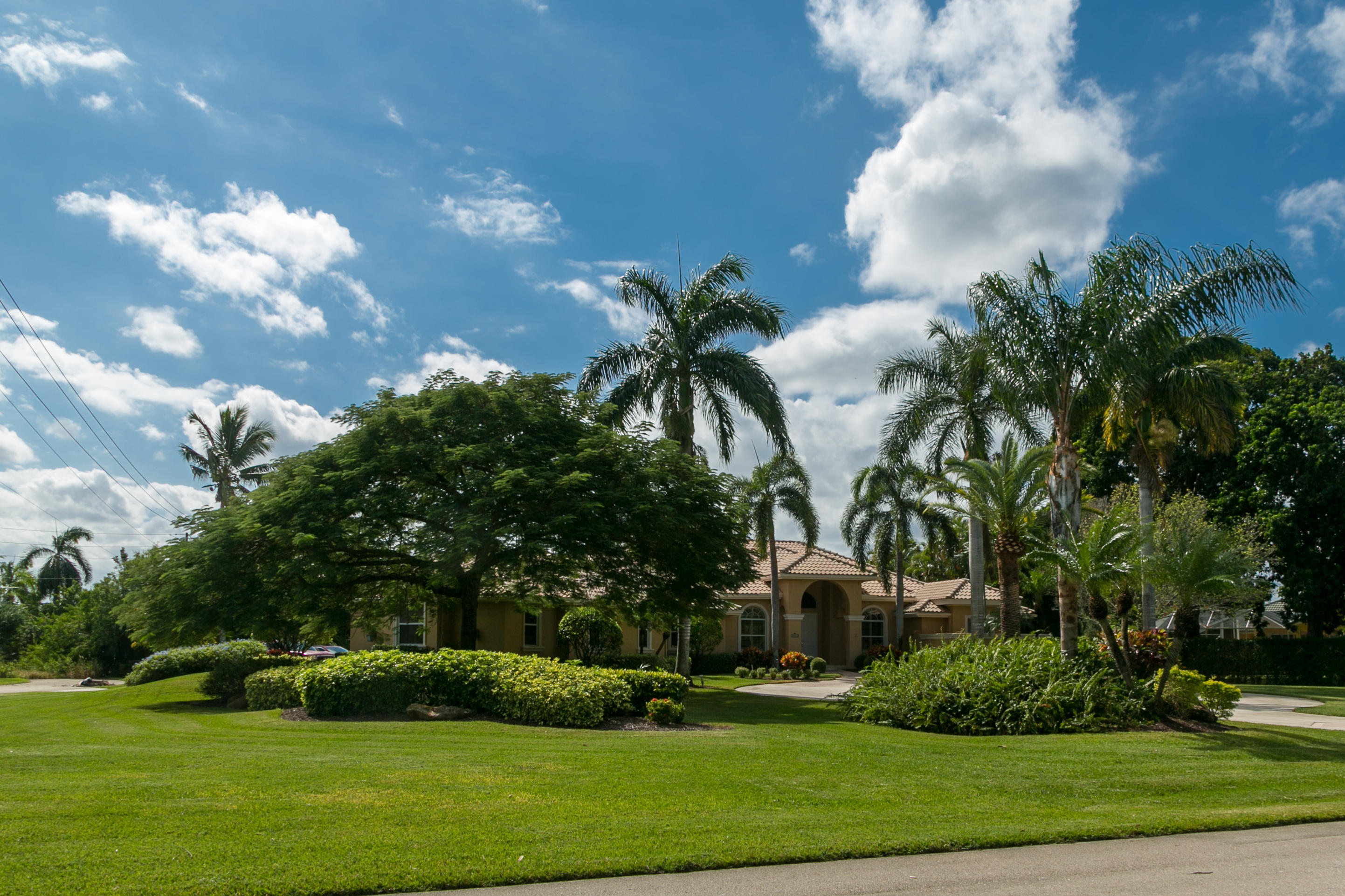 8666 Sawpine Road Delray Beach, FL 33446 - Photo 46 of 49 a front view of multi story residential apartment building with yard and green space