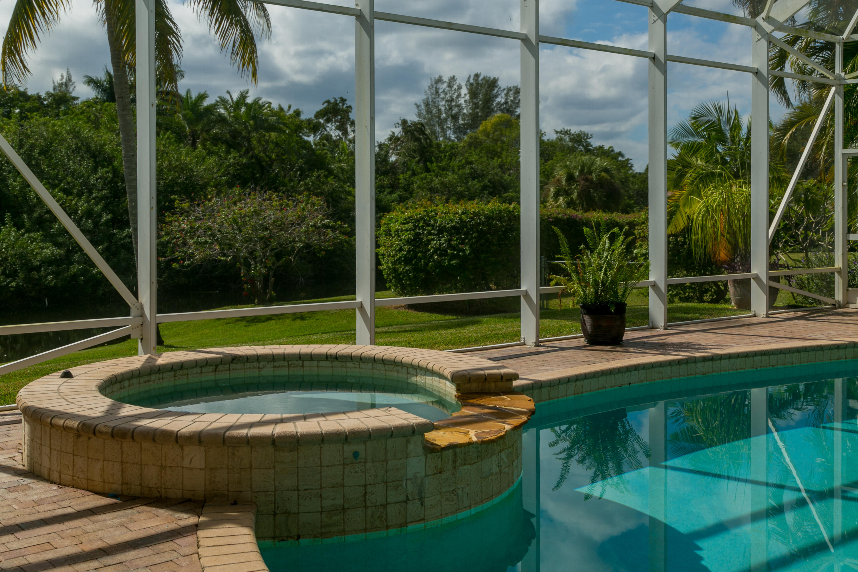 8666 Sawpine Road Delray Beach, FL 33446 - Photo 6 of 49 a view of a swimming pool with a patio and a yard