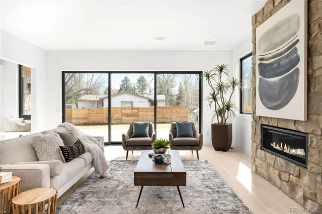 a living room with furniture a large window and a fireplace