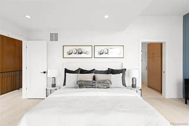 a bedroom with a bed and painting on the wall