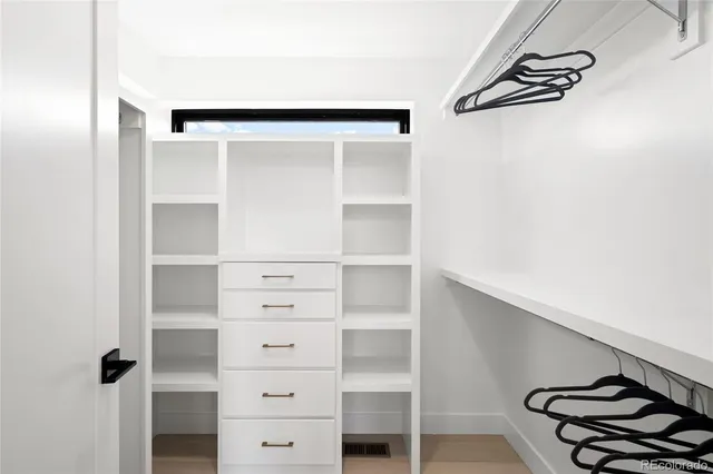 a view of walk in closet with empty racks