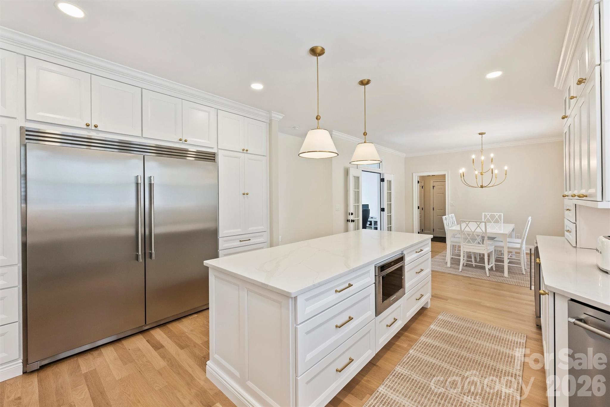 271 Beaten Path Road Mooresville, NC 28117 - Photo 22 of 47 a large kitchen with stainless steel appliances a stove a refrigerator a oven and white cabinets with wooden floor