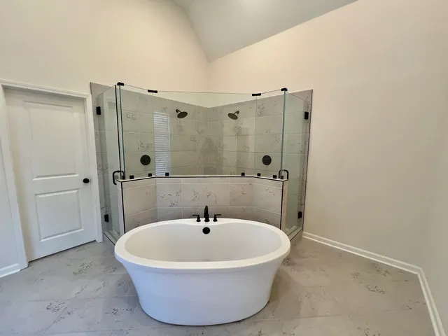 a white bath tub sitting in a bathroom and mirror