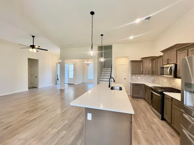 a large kitchen with kitchen island a sink stainless steel appliances and cabinets