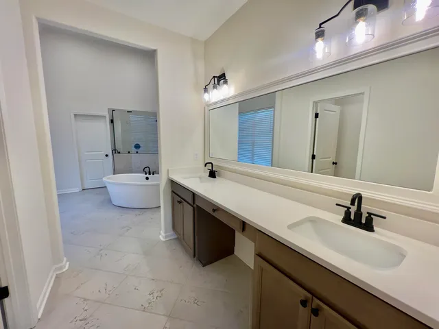 a bathroom with a double vanity sink a mirror and toilet