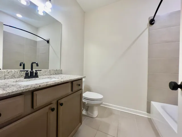 a bathroom with a granite countertop sink a toilet and a mirror