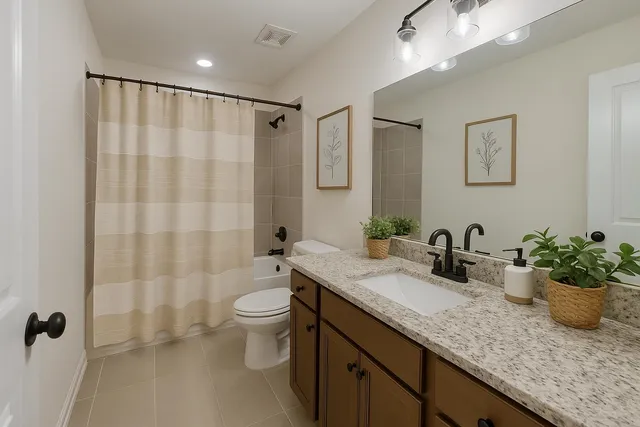 a bathroom with a granite countertop sink a toilet a mirror and shower