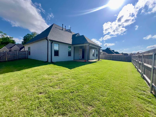 a view of a house with a big yard potted plants and large tree