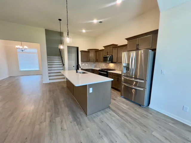 a kitchen with stainless steel appliances a refrigerator and a stove top oven