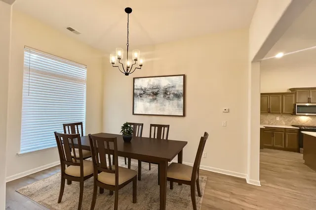a view of a dining room with furniture wooden floor and chandelier