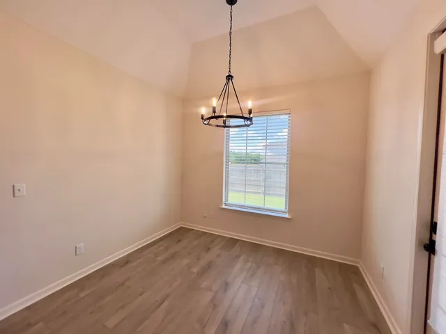 a view of a room with wooden floor ceiling fan and window