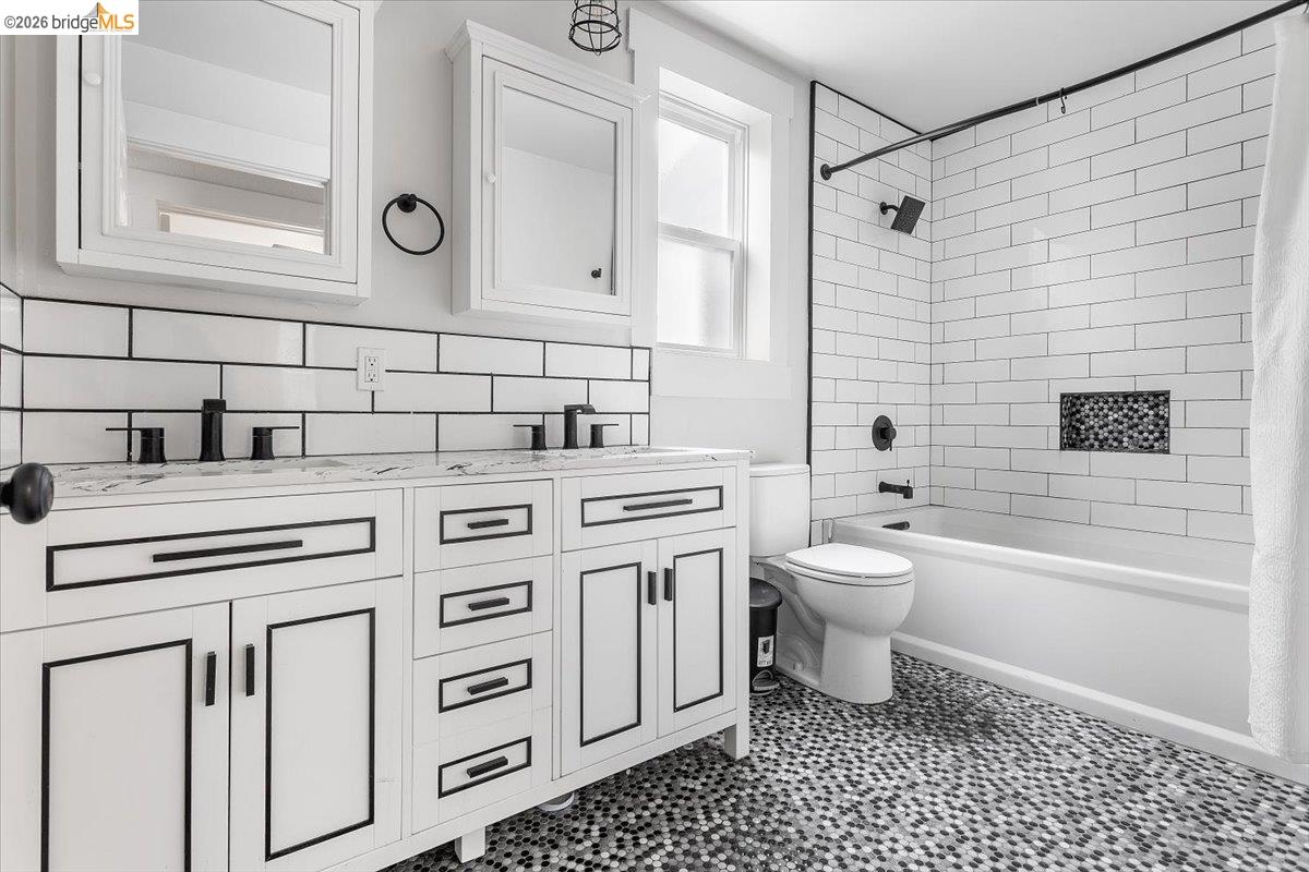 3029 Chestnut Street Oakland, CA 94608 - Photo 11 of 23 a bathroom with a granite countertop toilet a sink and a bathtub