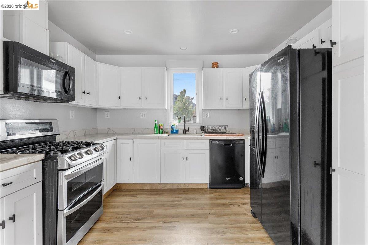 3029 Chestnut Street Oakland, CA 94608 - Photo 12 of 23 a kitchen with stainless steel appliances white cabinets and a stove top oven