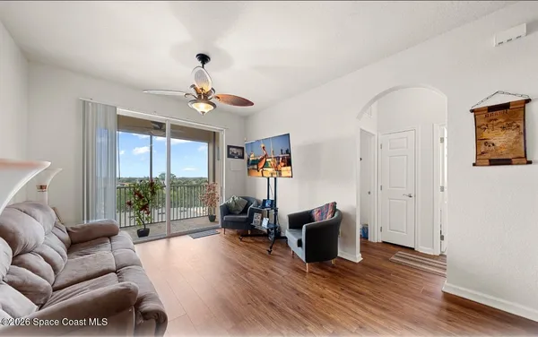 a living room with furniture a large window and a chandelier