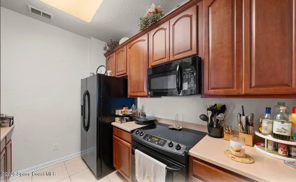 a kitchen with stainless steel appliances granite countertop a refrigerator a stove a sink and dishwasher with wooden floor
