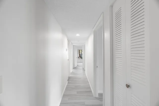a view of a hallway with wooden floor and staircase