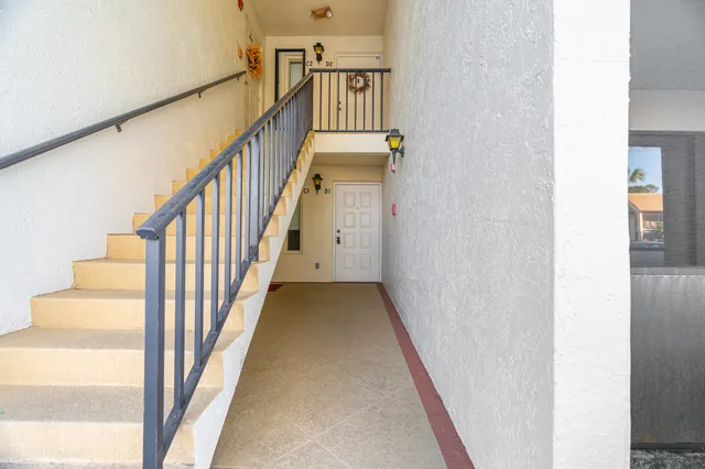 a view of staircase with wooden floor and white walls