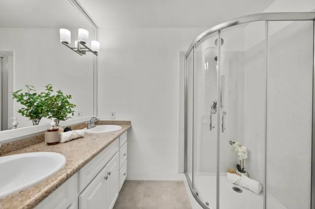 a bathroom with a granite countertop sink a mirror and a shower