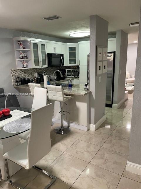 8340 Northwest 8th Street, Unit N12 Miami, FL 33126 - Photo 5 of 21 a living room with stainless steel appliances a couch cabinets and a window