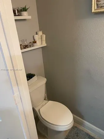 a white toilet sitting next to a small sink