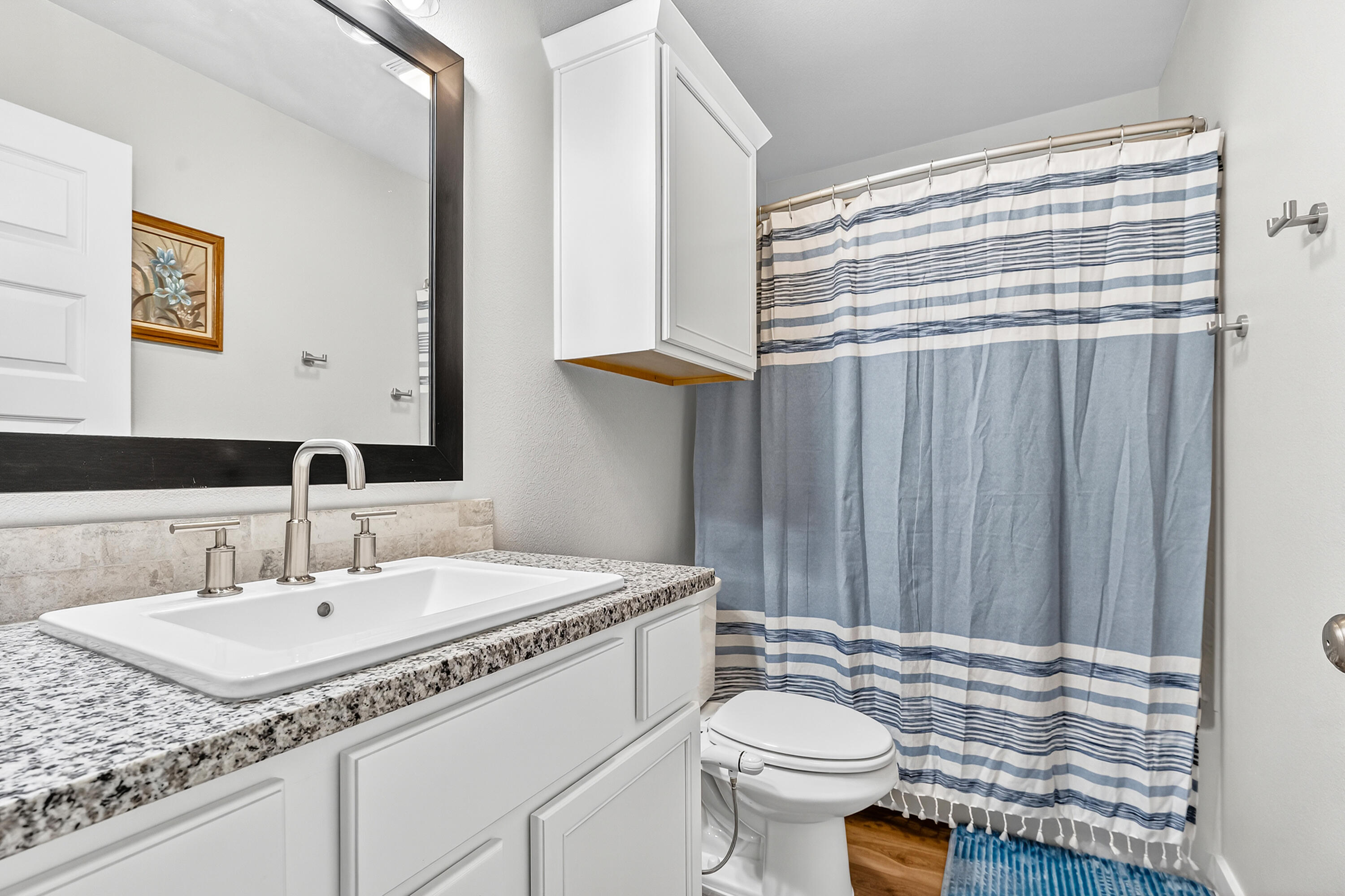 7231 29th Street Lubbock, TX 79407 - Photo 7 of 23 a bathroom with a granite countertop sink vanity mirror and toilet