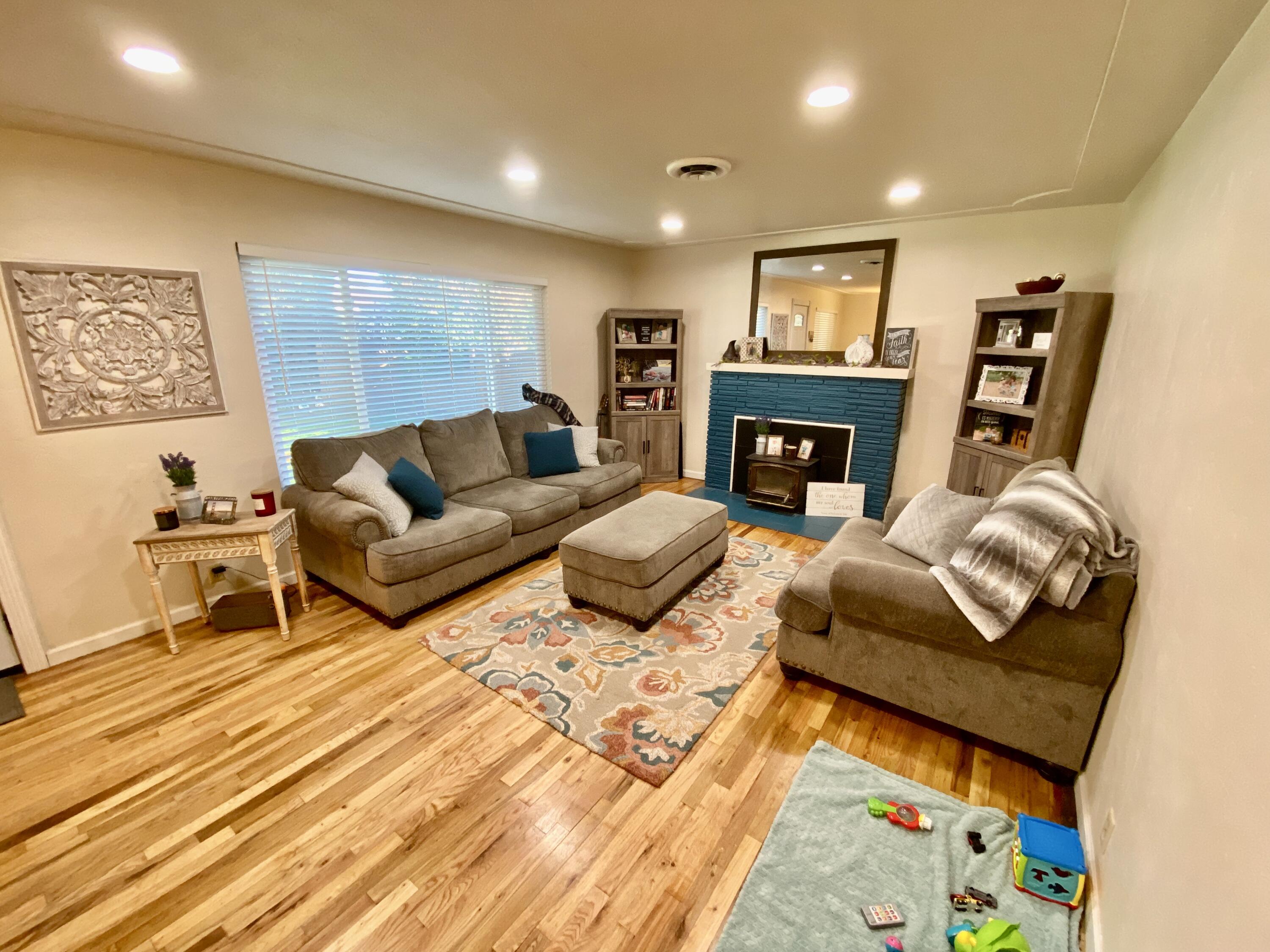 2890 Irwin Road Redding, CA 96002 - Photo 5 of 28 a living room with fireplace furniture and a wooden floor