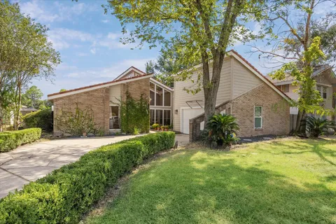 a view of a house with a yard and potted plants