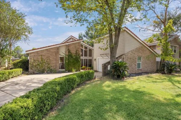 a view of a house with a yard and potted plants