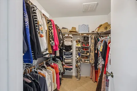 a view of walk in closet with clothes