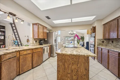 a kitchen with stainless steel appliances kitchen island granite countertop a sink and cabinets