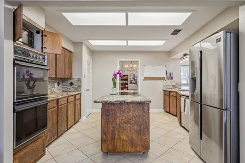 a kitchen with stainless steel appliances granite countertop a refrigerator and a stove