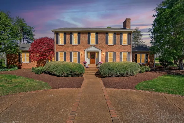 a front view of a house with yard and green space