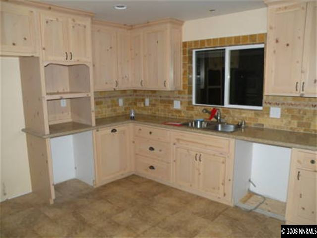 830 Foothill Road Gardnerville, NV 89460 - Photo 3 of 7 a kitchen with granite countertop white cabinets white appliances and sink