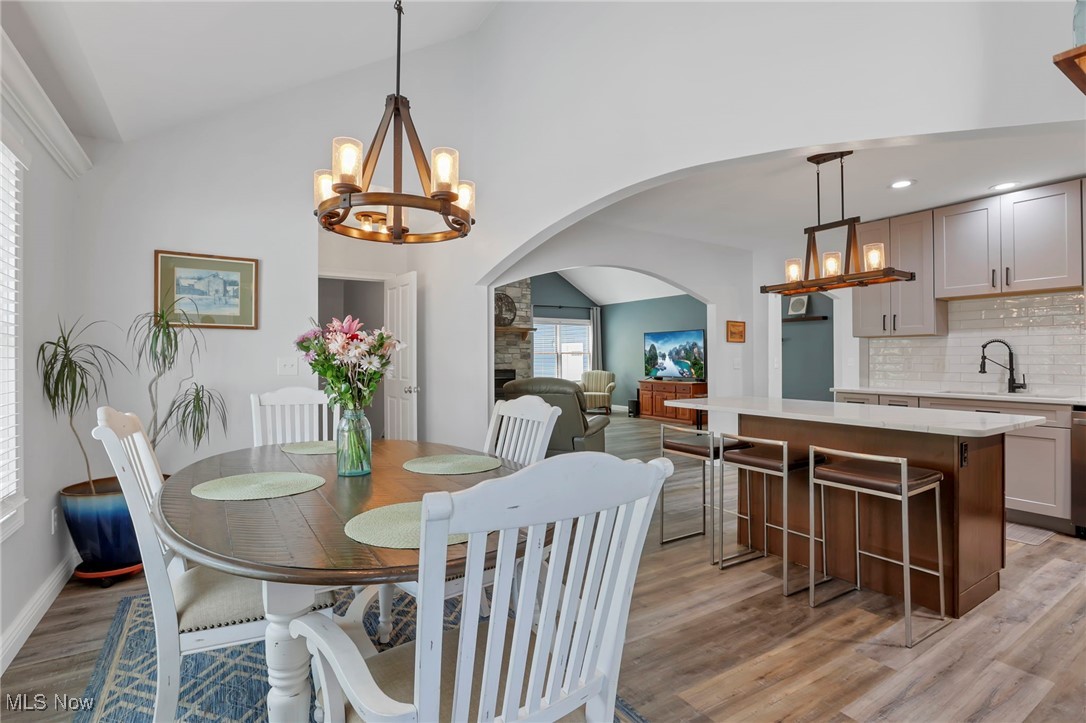 1890 Baltimore Road Northwest Lancaster, OH 43130 - Photo 29 of 50 Dining area featuring sink, light hardwood / wood-style flooring, an inviting chandelier, and lofted ceiling