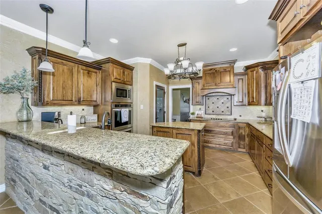a kitchen with stainless steel appliances granite countertop a sink refrigerator and cabinets
