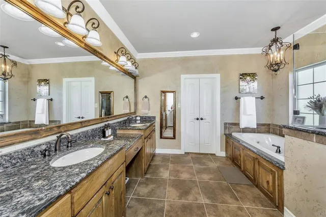 a large bathroom with a granite countertop double vanity sink a mirror and a shower