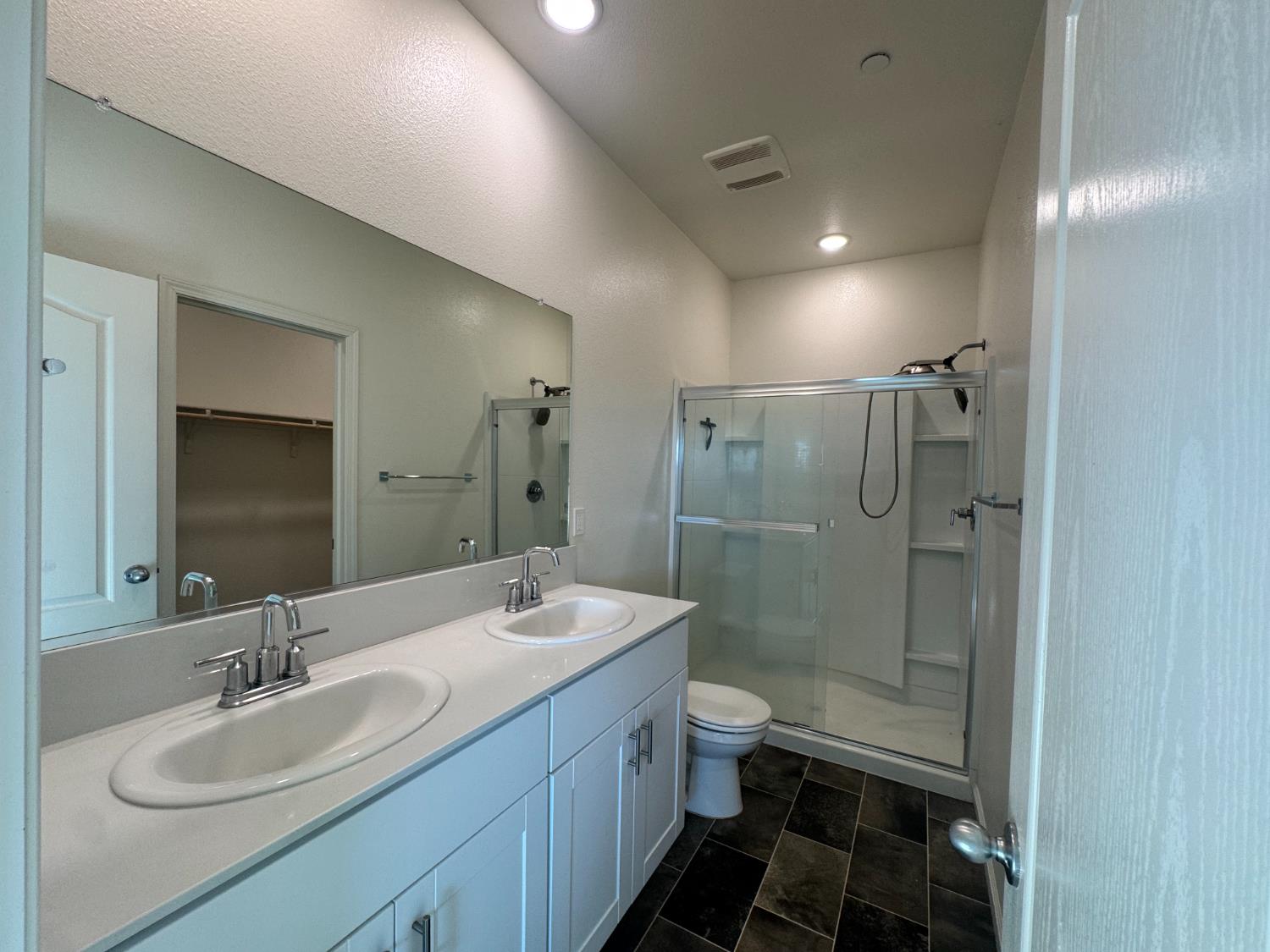 4271 Freemark Avenue Merced, CA 95348 - Photo 22 of 37 a bathroom with a double vanity sink toilet mirror and shower