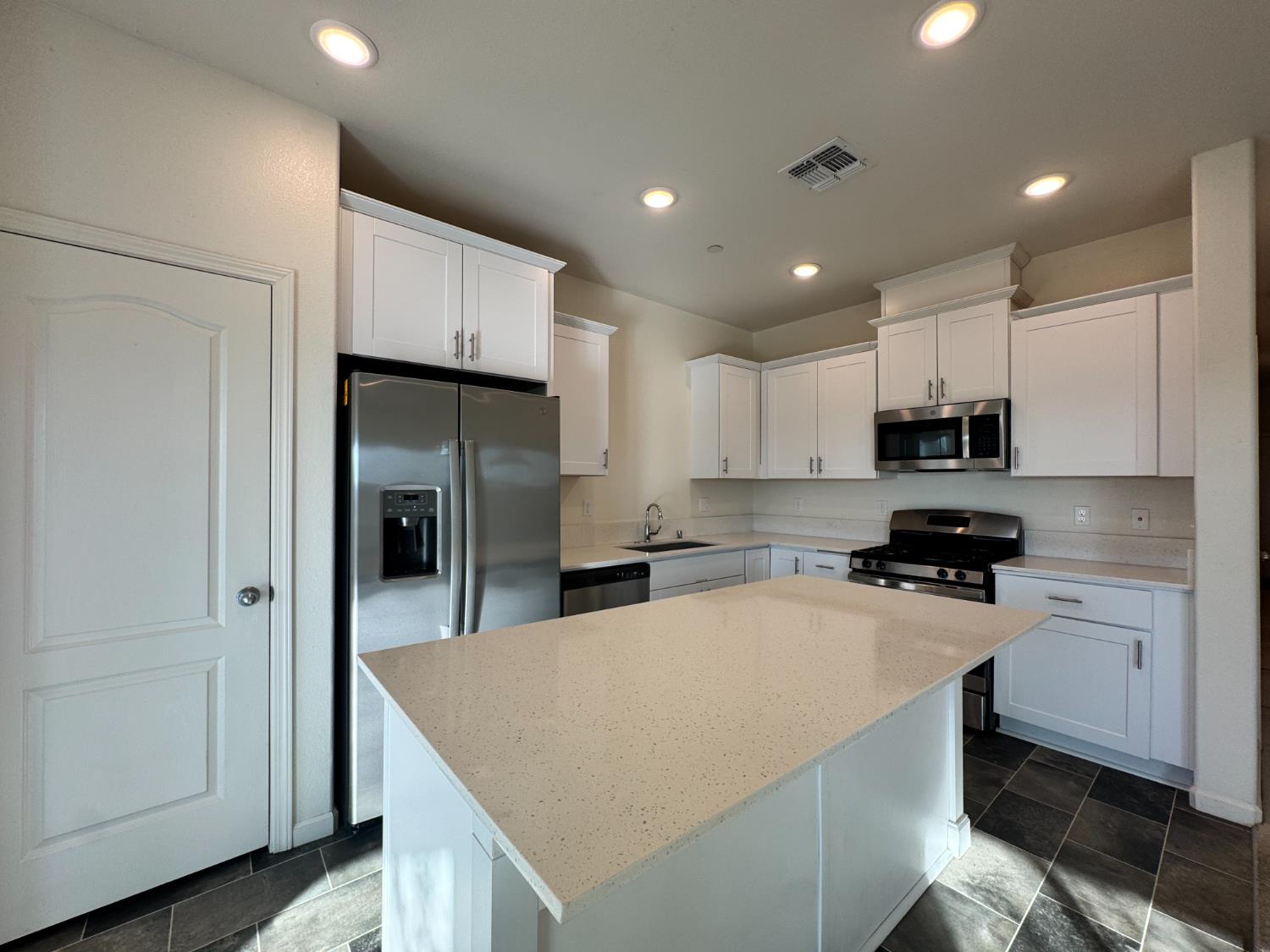 4271 Freemark Avenue Merced, CA 95348 - Photo 31 of 37 a kitchen with kitchen island a sink stainless steel appliances and cabinets