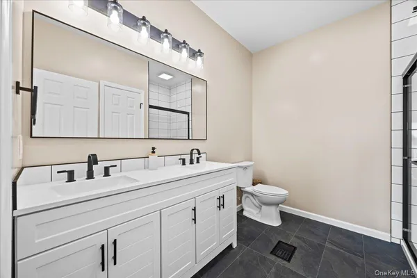a bathroom with a toilet sink and mirror