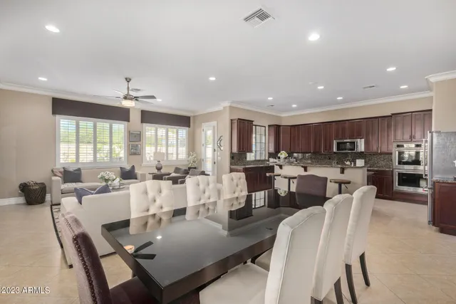 a living room with furniture a chandelier and a large mirror