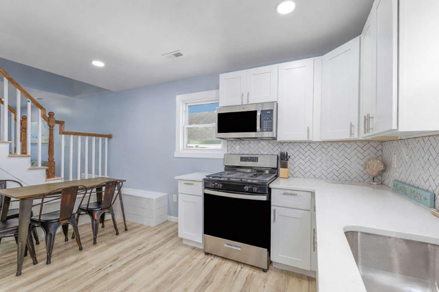 5 Kenvil Road North Cape May, NJ 08204 - Photo 7 of 19 a kitchen with stainless steel appliances a stove a sink a microwave a dining table and chairs